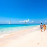 Plaża z palmami i turkusową wodą.