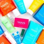 Produkty Yanis na stole, kolorowe opakowania, kosmetyki.