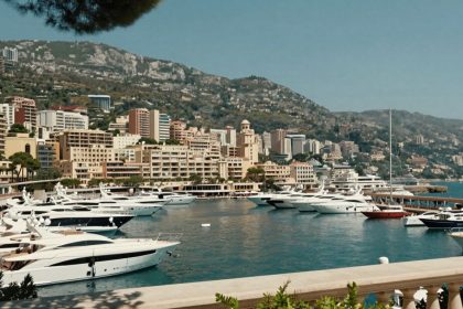 Luksusowe jachty w porcie Monako z eleganckimi budynkami.