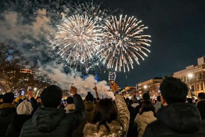 Sylwester 2025: fajerwerki nad miastem, ludzie świętują.