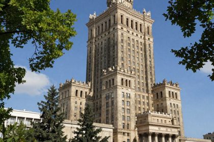 Pałac Kultury i Nauki w Warszawie, zielone drzewa, błękitne niebo.