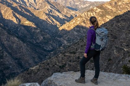 Kobieta podziwiająca górski krajobraz podczas podróży.