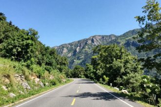 Góry i droga w słoneczny dzień, zapraszające do podróży.